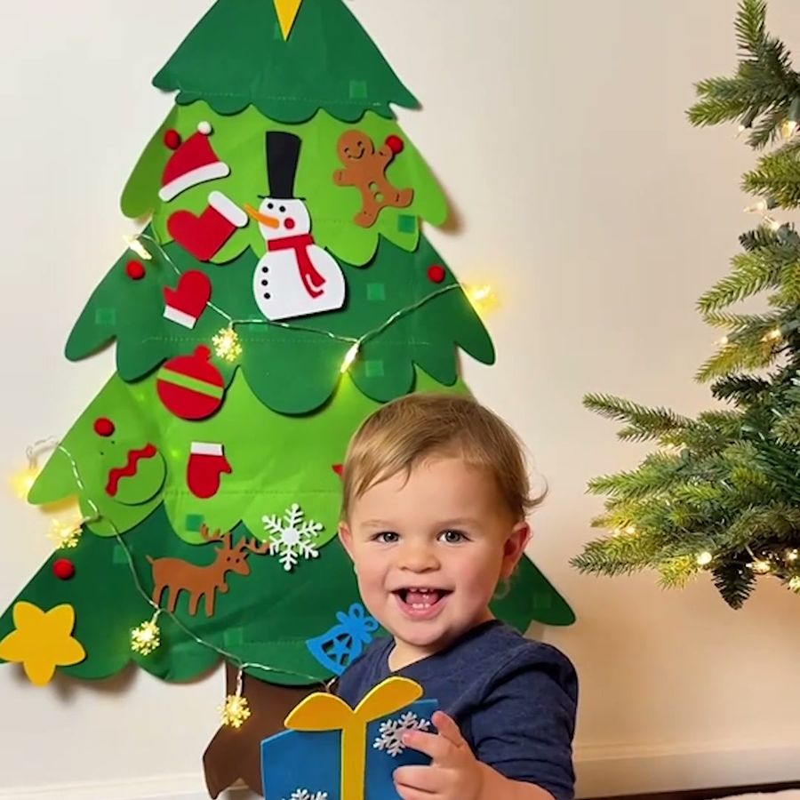 Niño sonriendo junto a su arbolito
